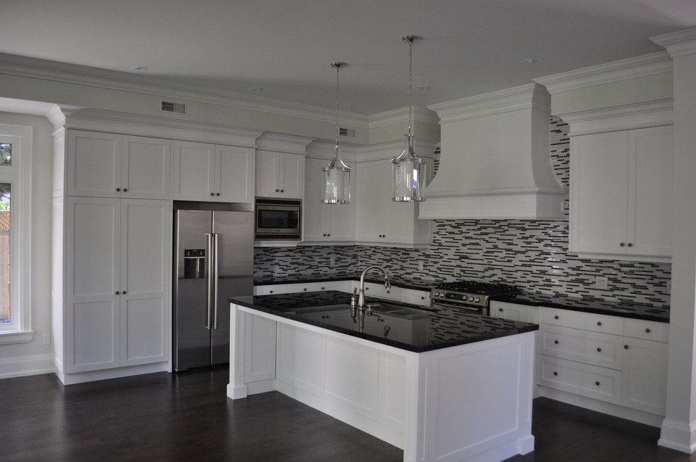 Inspiration for a large modern l-shaped eat-in kitchen in Toronto with a double-bowl sink, shaker cabinets, white cabinets, solid surface benchtops, black splashback, matchstick tile splashback, stainless steel appliances, dark hardwood floors and with island.