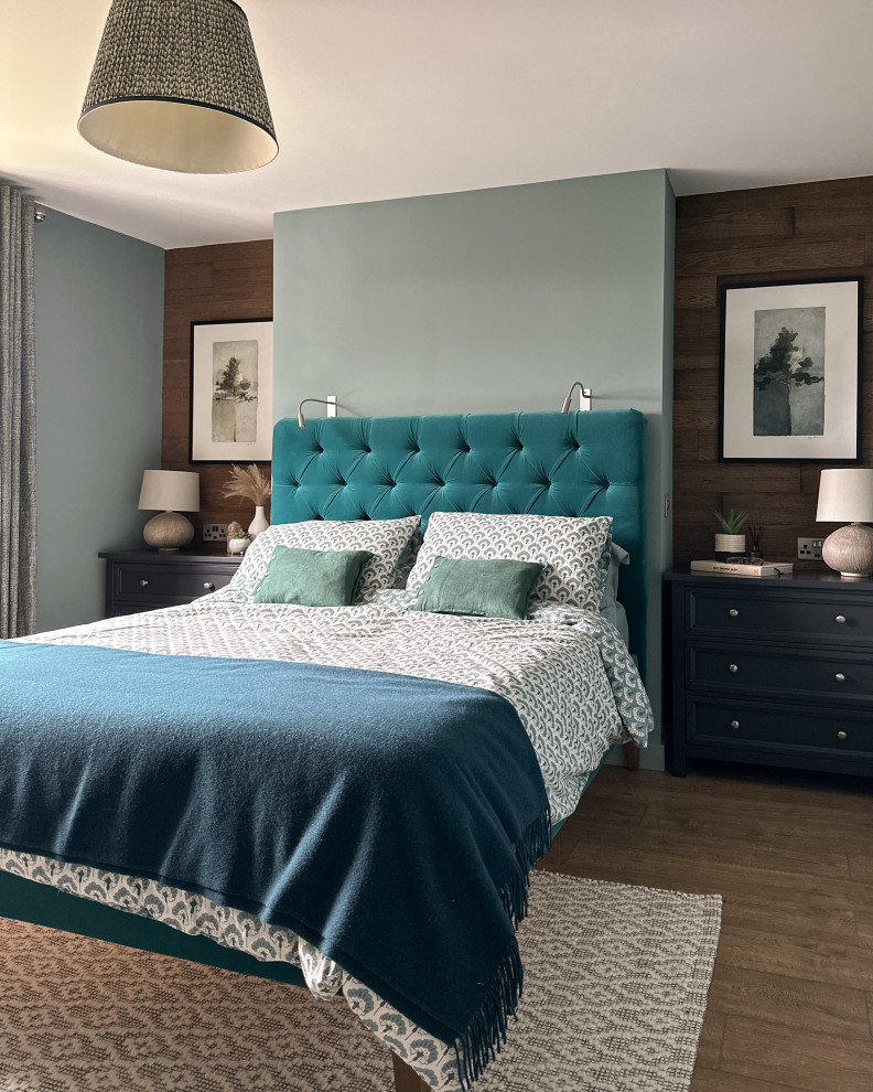 Mittelgroßes Klassisches Hauptschlafzimmer mit blauer Wandfarbe, Laminat, braunem Boden und Wandpaneelen in West Midlands