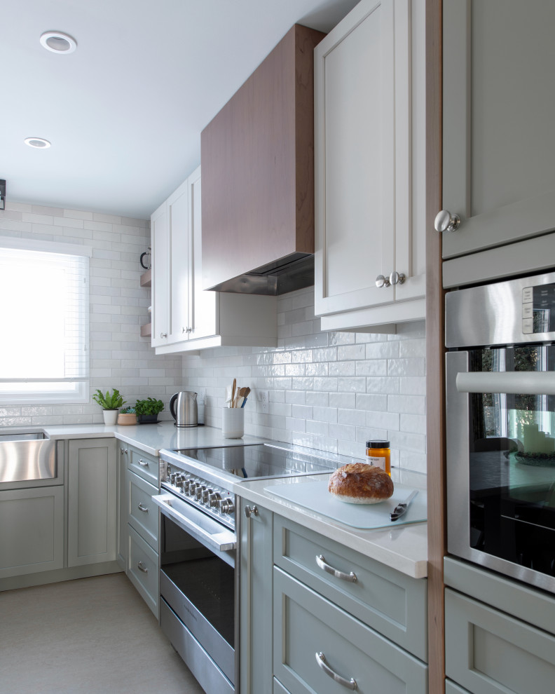 Mid-sized transitional u-shaped linoleum floor and gray floor eat-in kitchen photo in Ottawa with a farmhouse sink, shaker cabinets, gray cabinets, quartz countertops, white backsplash, subway tile backsplash, stainless steel appliances, an island and white countertops