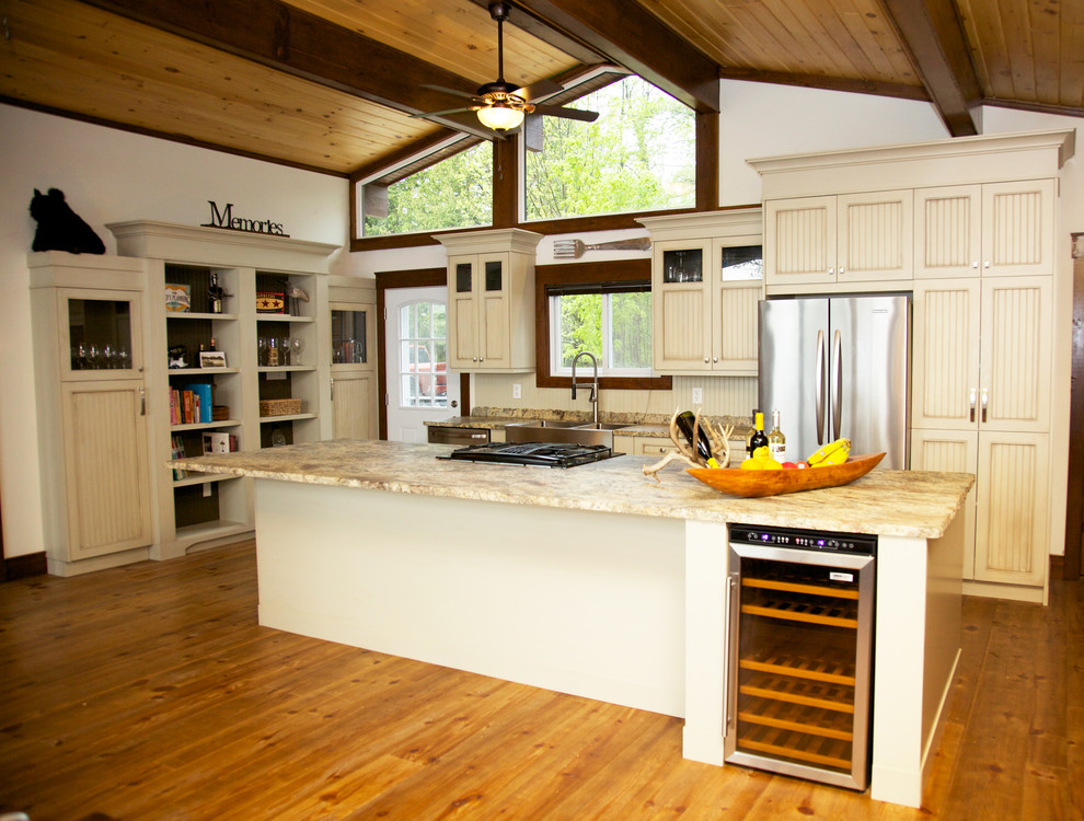 This is an example of a mid-sized country l-shaped eat-in kitchen in Toronto with a farmhouse sink, beaded inset cabinets, granite benchtops, stainless steel appliances, medium hardwood floors and with island.