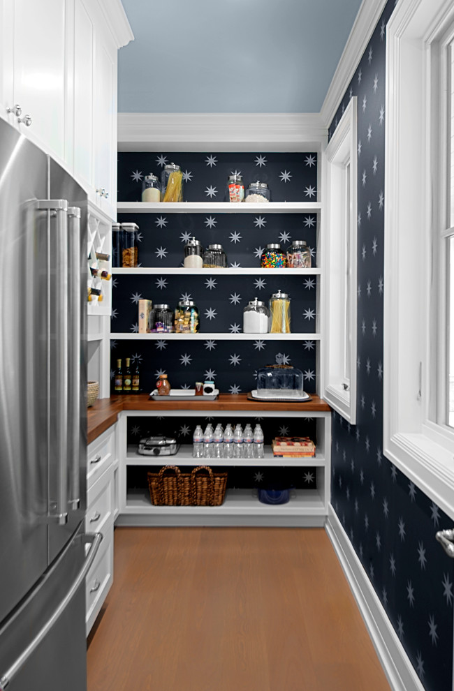 Inspiration for a mid-sized traditional l-shaped kitchen pantry in Grand Rapids with shaker cabinets, white cabinets, wood benchtops, black splashback, stainless steel appliances, medium hardwood floors, no island, brown floor and brown benchtop.