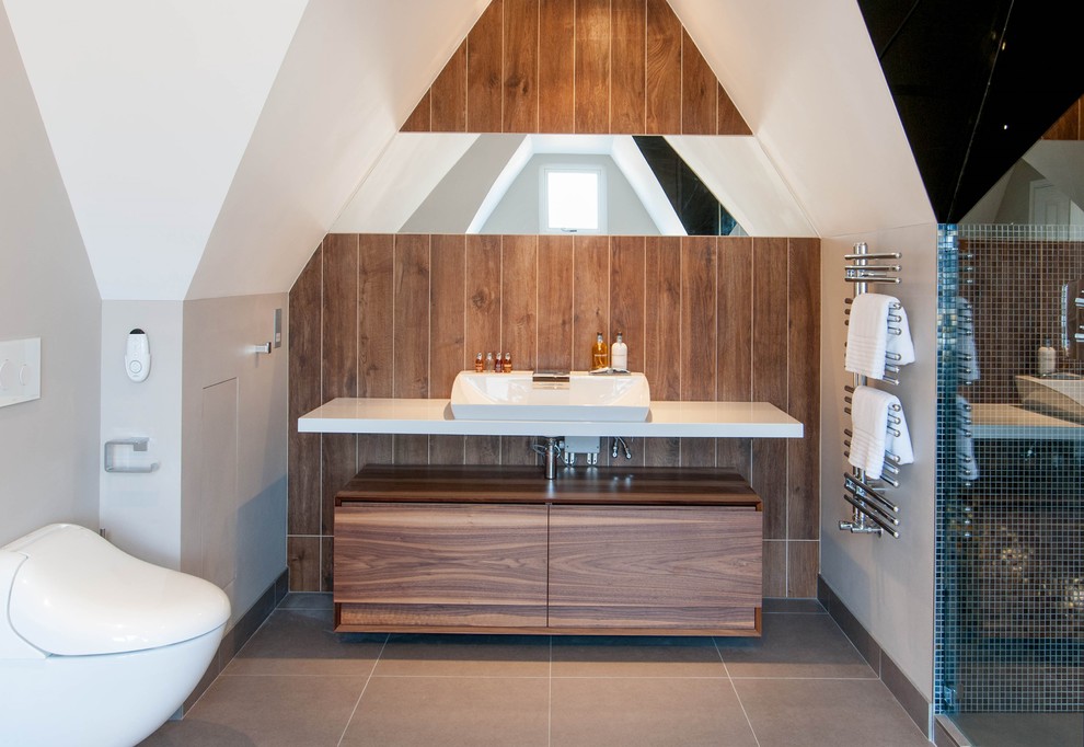 Large contemporary bathroom in London with porcelain floors, a vessel sink, flat-panel cabinets, a wall-mount toilet, medium wood cabinets, an alcove shower, multi-coloured tile, porcelain tile and white walls.