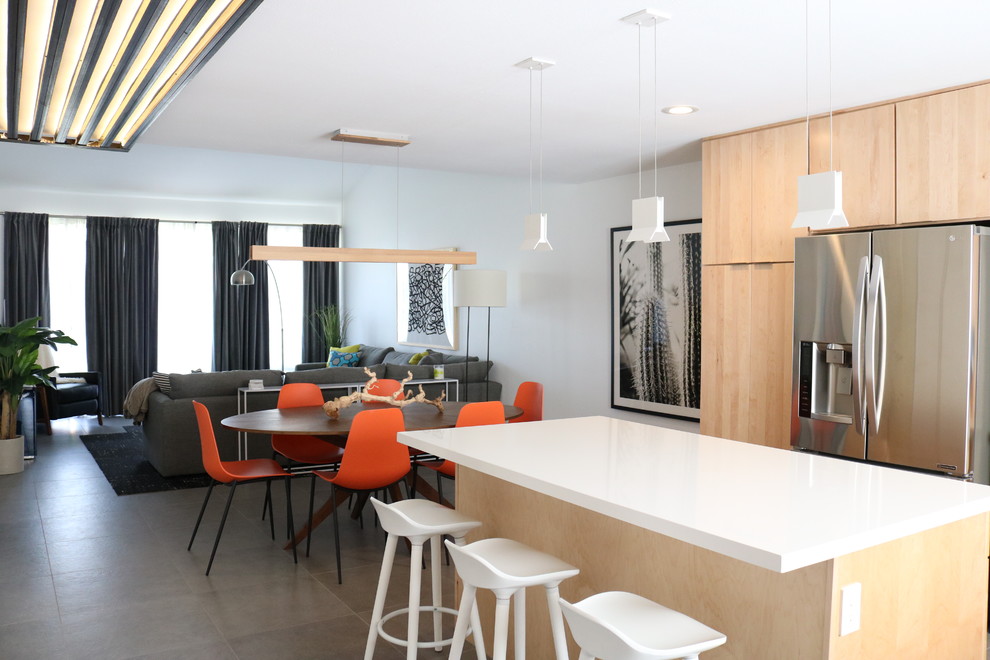 Design ideas for a large contemporary l-shaped open plan kitchen in Phoenix with an undermount sink, flat-panel cabinets, light wood cabinets, quartz benchtops, blue splashback, ceramic splashback, stainless steel appliances, concrete floors, with island, grey floor and white benchtop.