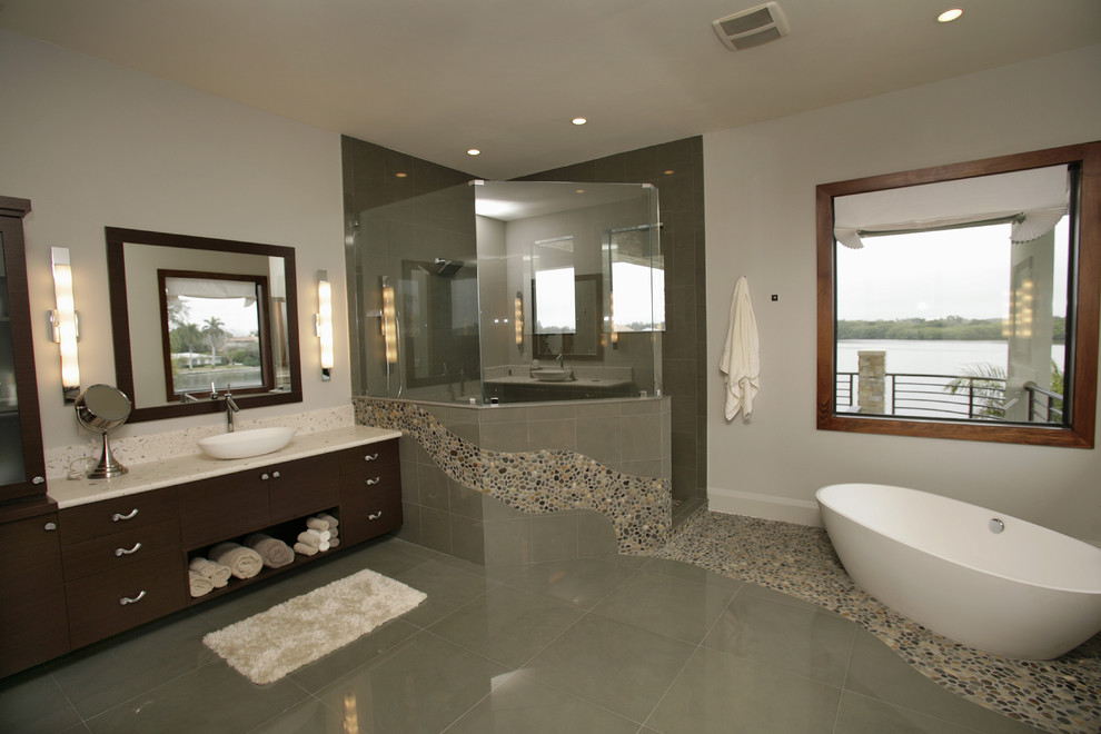 This is an example of a modern bathroom in Tampa with a freestanding tub, pebble tile and pebble tile floors.