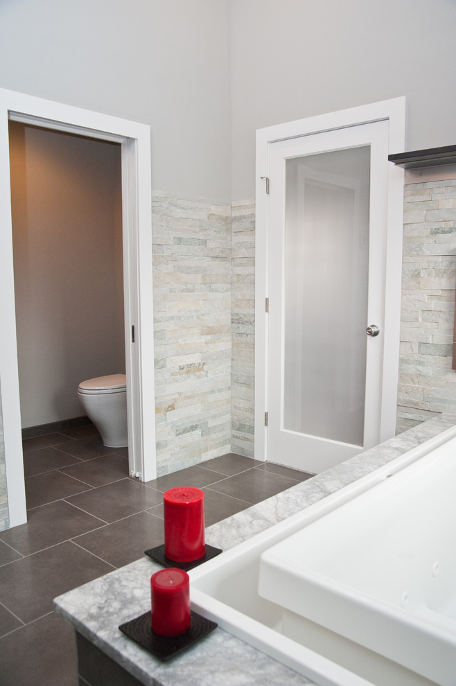 Design ideas for a large contemporary master bathroom in Newark with shaker cabinets, dark wood cabinets, a drop-in tub, a one-piece toilet, gray tile, white tile, stone tile, grey walls, ceramic floors, an undermount sink and marble benchtops.