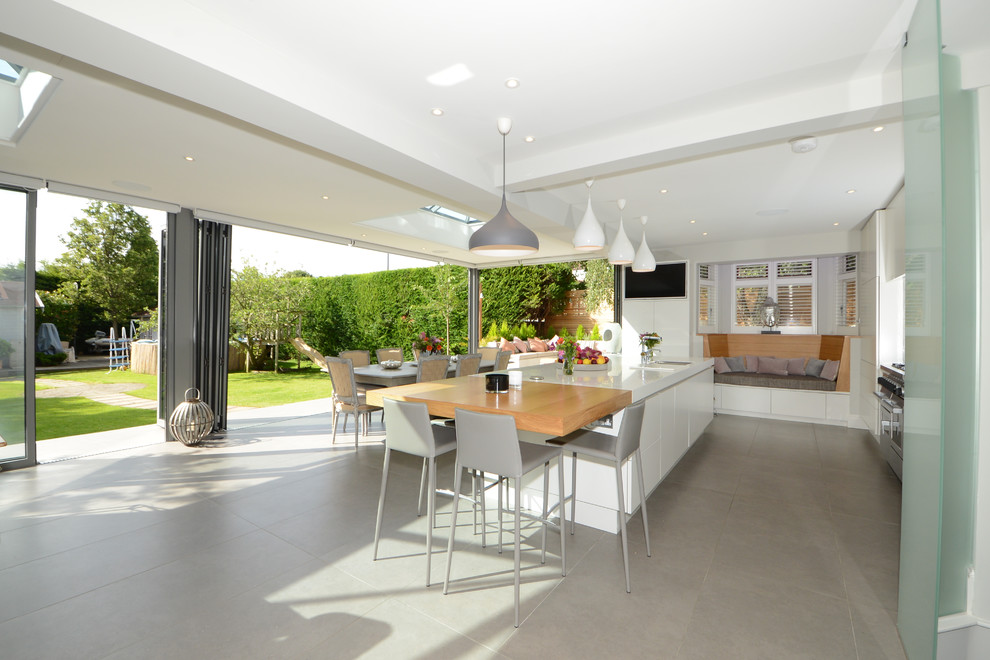 This is an example of a mid-sized contemporary single-wall kitchen in Other with an undermount sink, flat-panel cabinets, white cabinets, stainless steel appliances, ceramic floors, with island, grey floor, blue splashback and ceramic splashback.