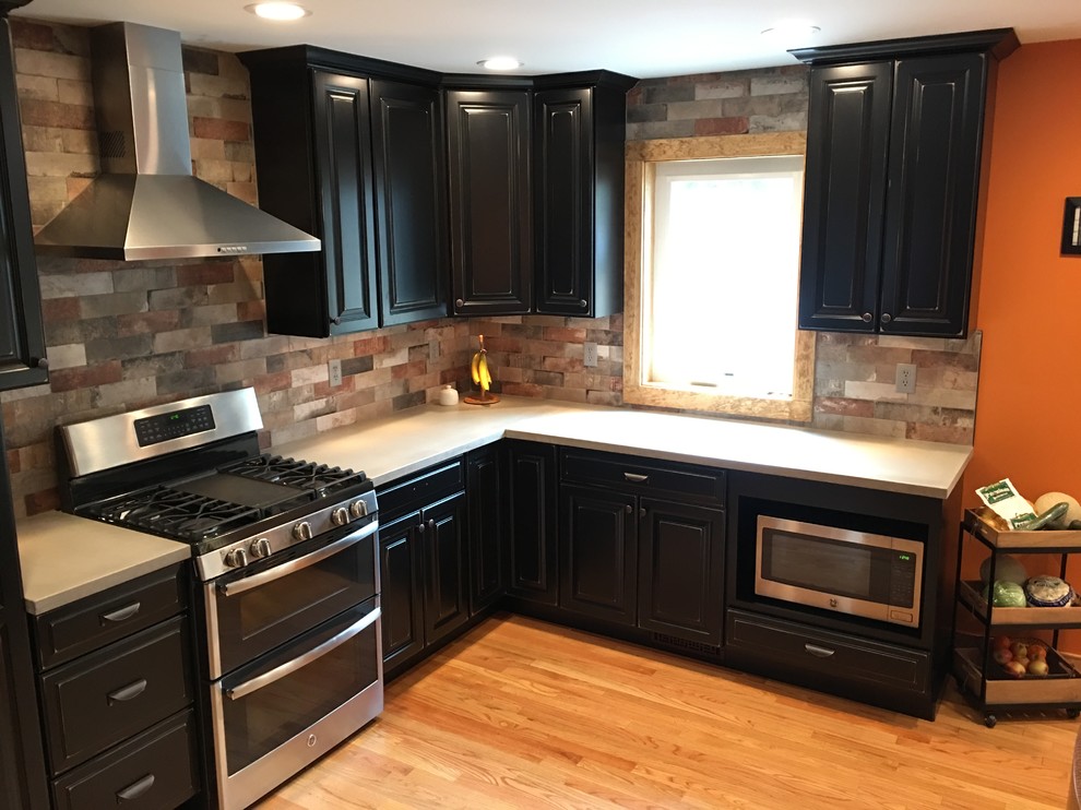 Mountain style kitchen photo in New York with concrete countertops and brick backsplash