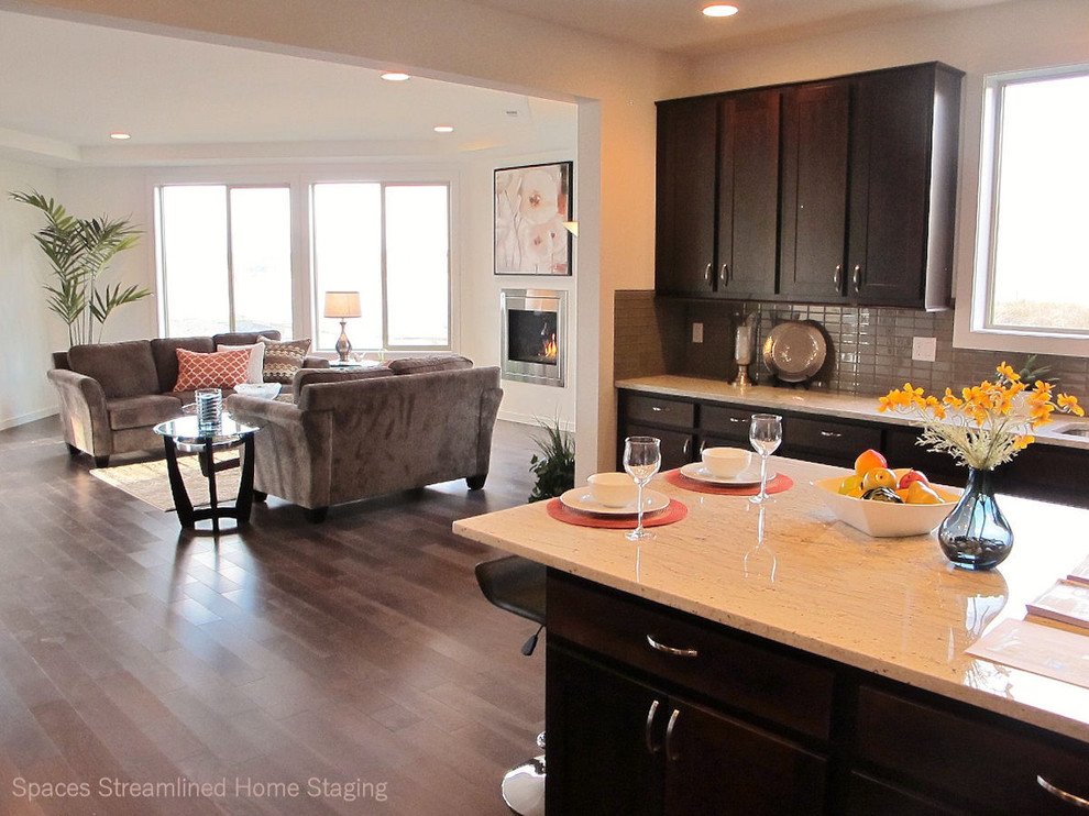Transitional dark wood floor kitchen photo in Seattle with recessed-panel cabinets, dark wood cabinets, granite countertops, gray backsplash, glass tile backsplash, white walls and an island