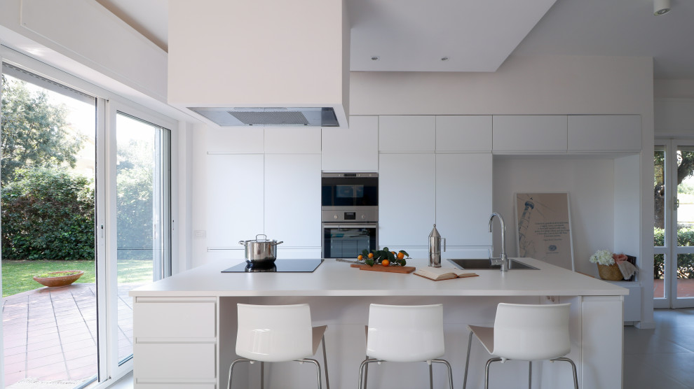 Ispirazione per una grande cucina minimal con lavello da incasso, ante lisce, ante bianche, top in laminato, elettrodomestici in acciaio inossidabile, pavimento in gres porcellanato, pavimento grigio, top bianco e soffitto ribassato