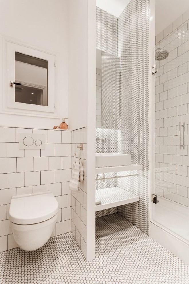 This is an example of a mid-sized mediterranean 3/4 bathroom in Other with white cabinets, white tile, mosaic tile, white walls, white benchtops, a vessel sink, white floor, an alcove shower, a wall-mount toilet, mosaic tile floors and a hinged shower door.
