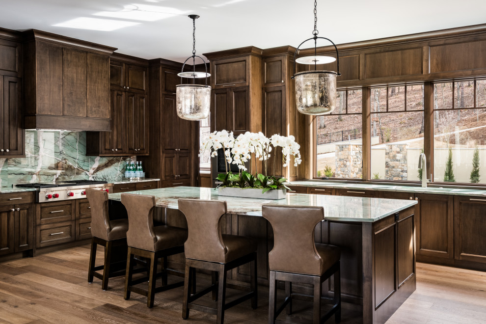 Example of a large transitional u-shaped medium tone wood floor and brown floor kitchen design with an undermount sink, dark wood cabinets, quartzite countertops, green backsplash, stone slab backsplash, paneled appliances, an island, green countertops and recessed-panel cabinets