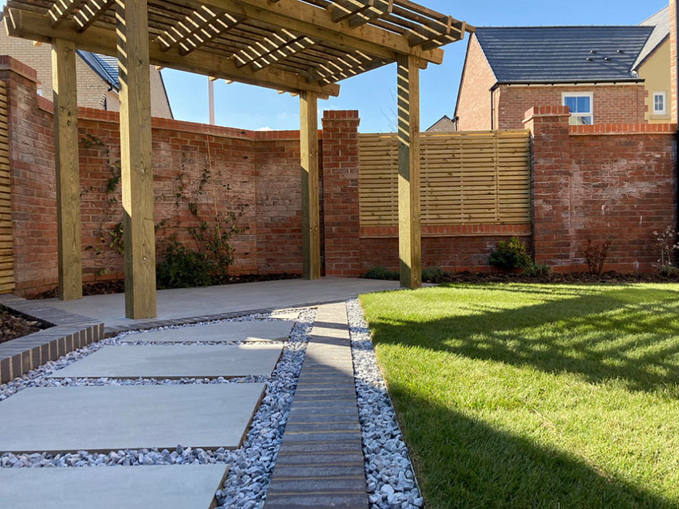 Immagine di un giardino formale minimal esposto a mezz'ombra di medie dimensioni e dietro casa in estate con sassi di fiume e recinzione in legno