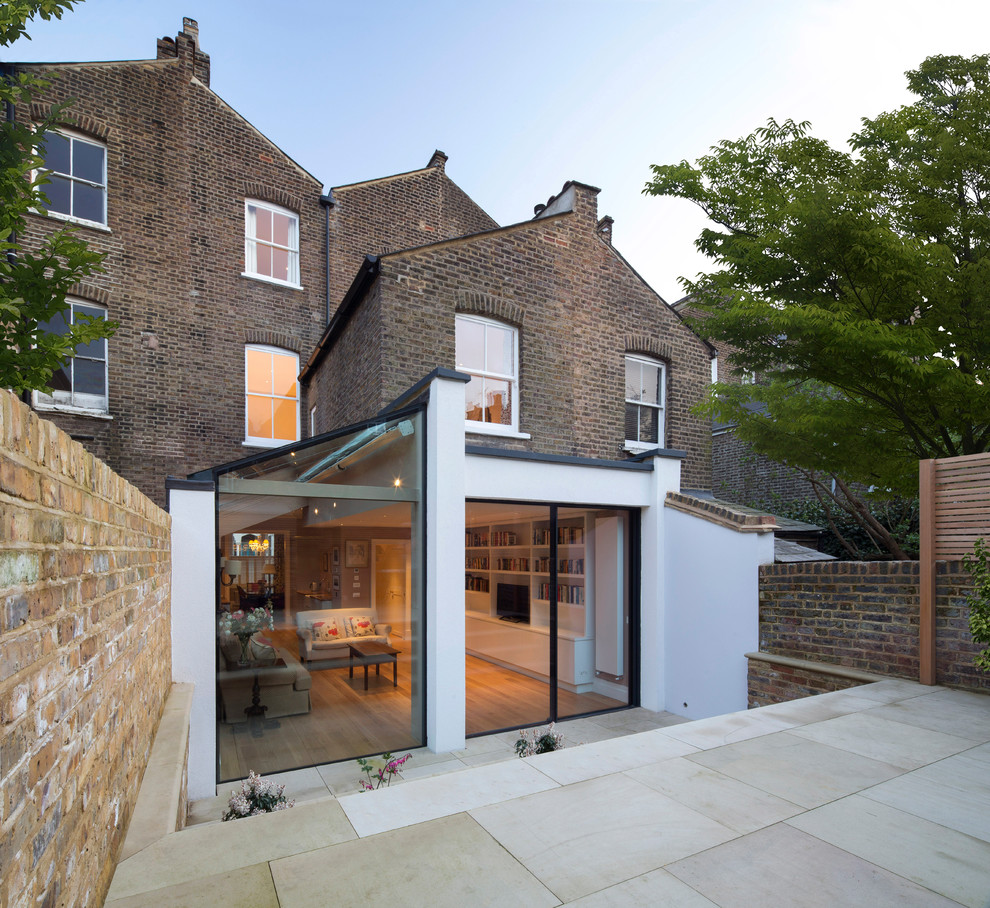 Design ideas for a mid-sized contemporary three-storey glass townhouse exterior in London.