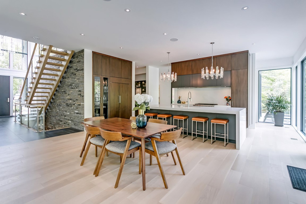 Open concept kitchen - large transitional l-shaped light wood floor open concept kitchen idea in Toronto with an undermount sink, flat-panel cabinets, gray cabinets, quartzite countertops, white backsplash, porcelain backsplash, stainless steel appliances, an island and white countertops