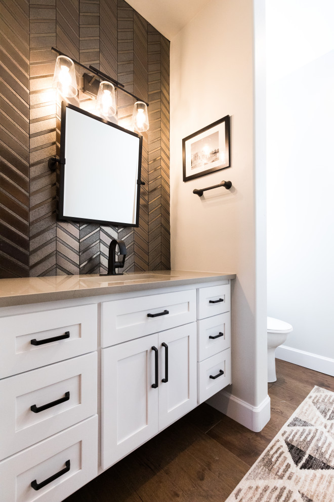 This is an example of a small 3/4 bathroom in Albuquerque with shaker cabinets, white cabinets, an alcove tub, an alcove shower, a two-piece toilet, brown tile, porcelain tile, grey walls, porcelain floors, an undermount sink, engineered quartz benchtops, grey floor, a sliding shower screen, a double vanity and a built-in vanity.