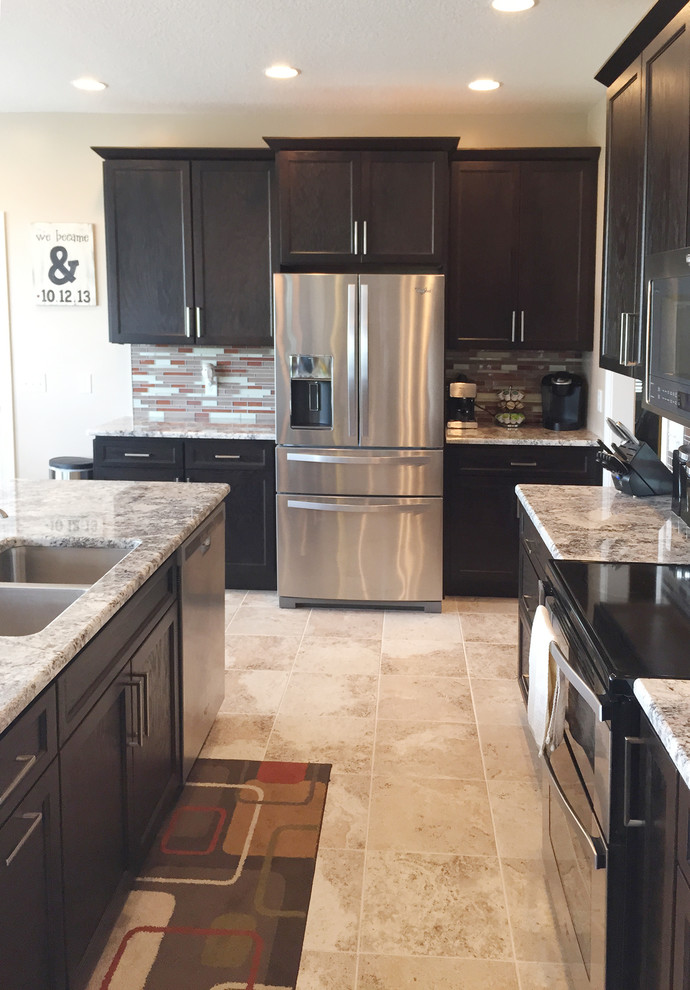 Open concept kitchen - mid-sized transitional l-shaped open concept kitchen idea with black cabinets, stainless steel appliances, an island, an undermount sink, recessed-panel cabinets and multicolored backsplash