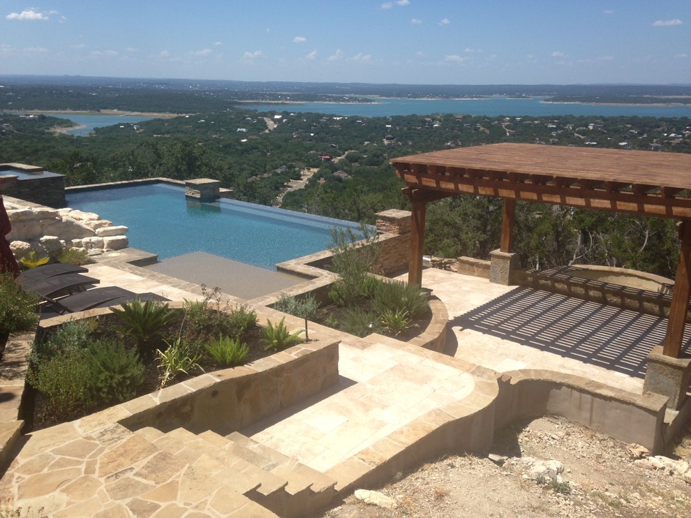Photo of a mid-sized mediterranean backyard rectangular infinity pool in Austin with a hot tub and concrete pavers.