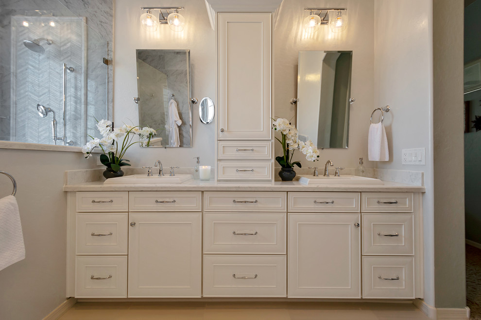 Inspiration for a large transitional master gray tile and marble tile porcelain tile and gray floor freestanding bathtub remodel in Phoenix with recessed-panel cabinets, white cabinets, gray walls, a drop-in sink, quartz countertops and white countertops