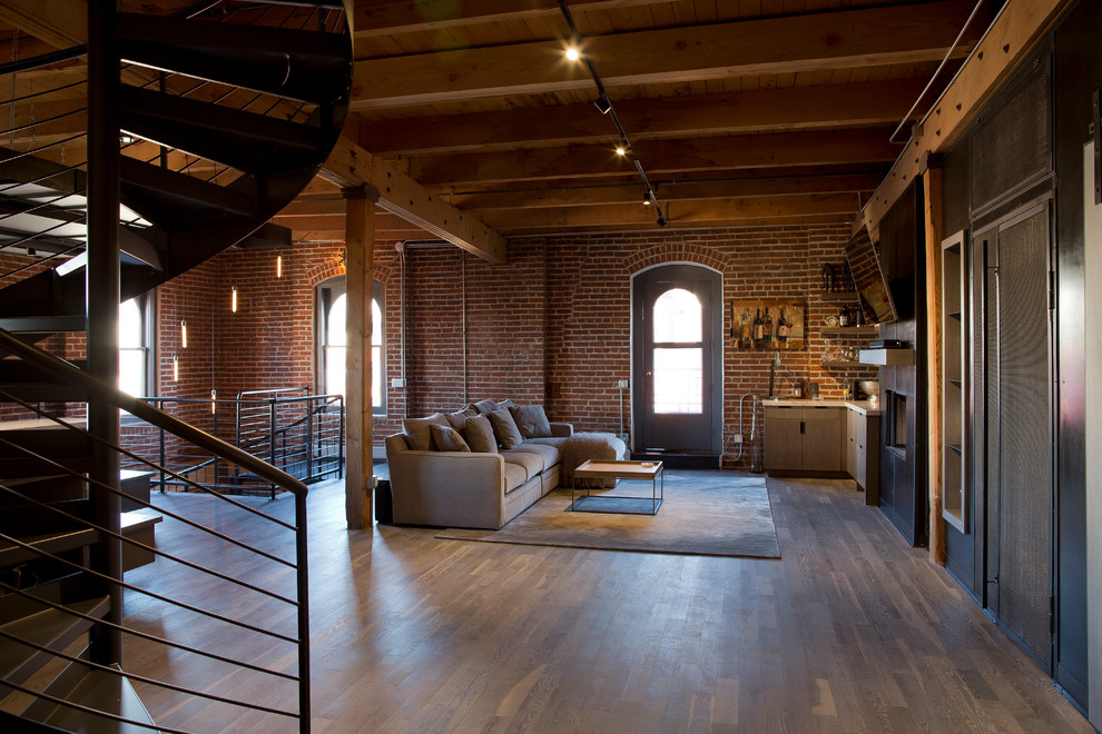 Design ideas for a large industrial loft-style living room in Denver with dark hardwood floors, a standard fireplace, a metal fireplace surround, a wall-mounted tv and brown floor.
