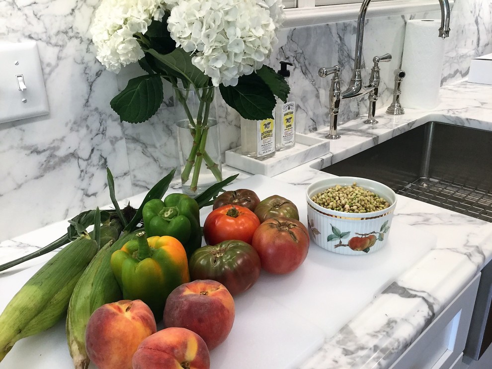 Example of a mid-sized transitional galley medium tone wood floor and brown floor enclosed kitchen design with shaker cabinets, white cabinets, marble countertops, white backsplash, marble backsplash, no island and a farmhouse sink