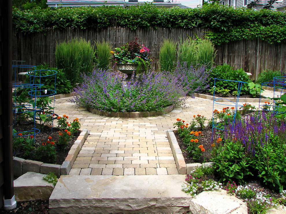 This is an example of a traditional backyard garden in Chicago with a vegetable garden and brick pavers.
