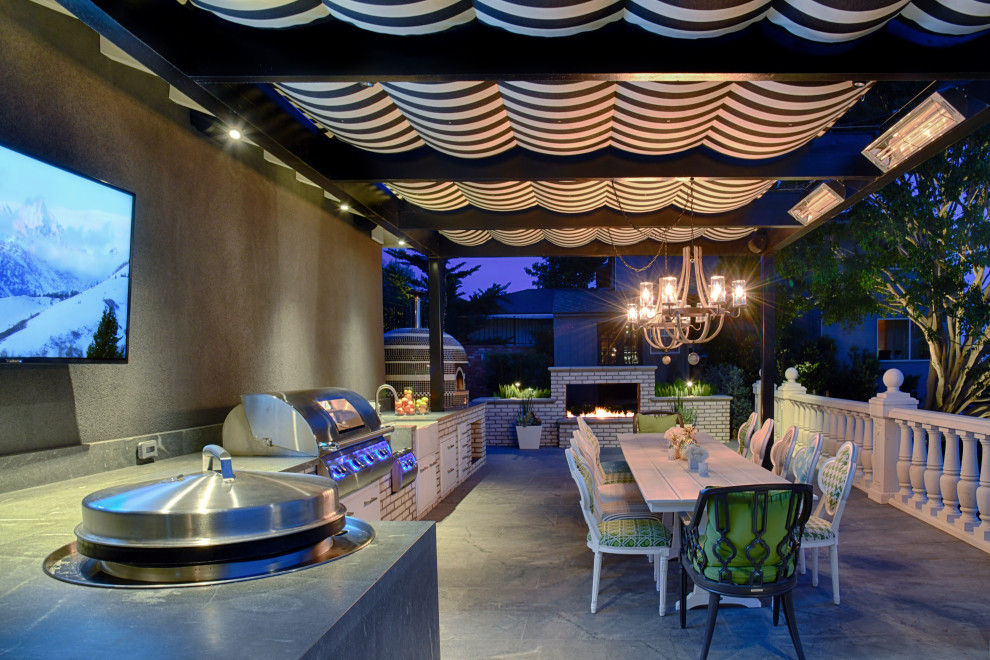 Modern backyard patio in San Diego with an outdoor kitchen, natural stone pavers and a pergola.