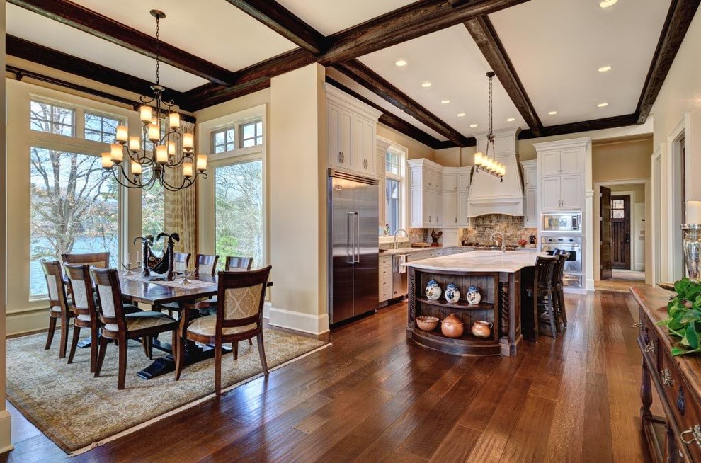 Huge transitional medium tone wood floor and brown floor great room photo with beige walls, no fireplace and a stone fireplace