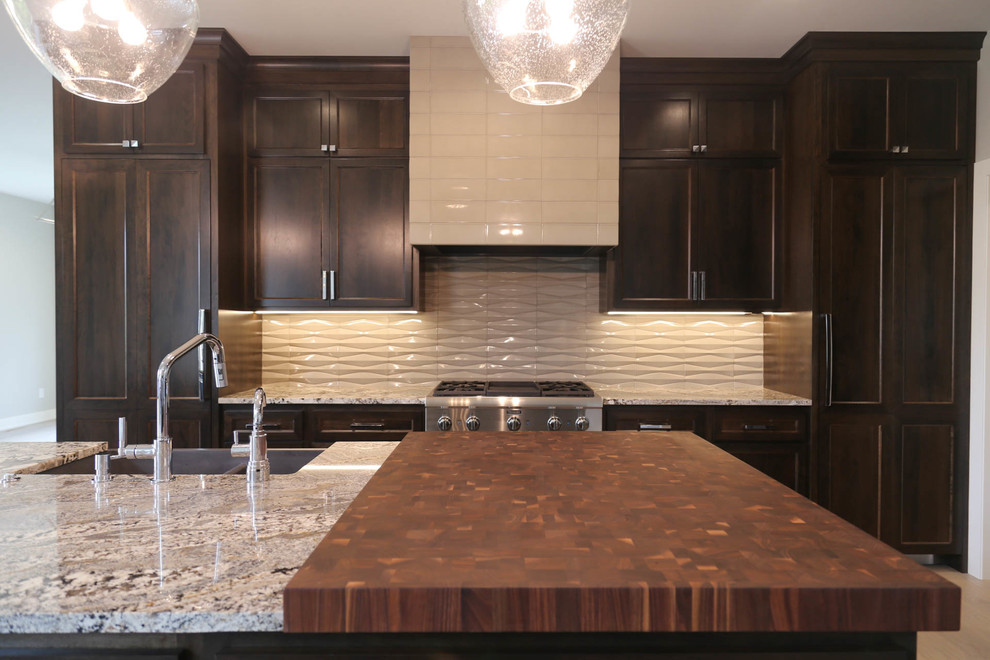 Inspiration for a large transitional l-shaped light wood floor and beige floor eat-in kitchen remodel with a farmhouse sink, recessed-panel cabinets, dark wood cabinets, granite countertops, gray backsplash, porcelain backsplash, stainless steel appliances, an island and multicolored countertops