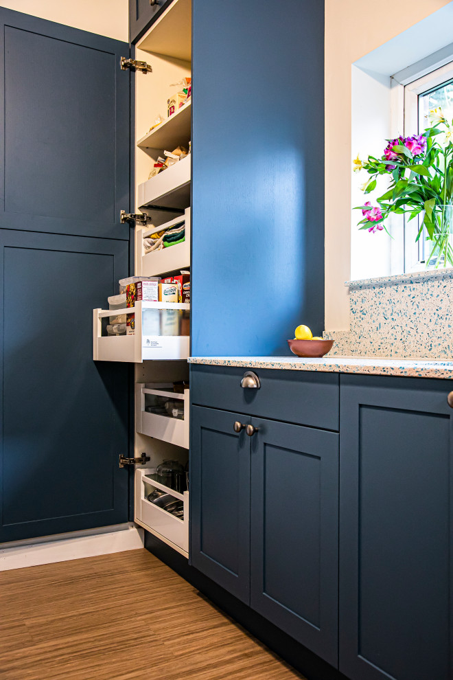 Foto på ett litet eklektiskt flerfärgad l-kök, med en undermonterad diskho, skåp i shakerstil, blå skåp, bänkskiva i återvunnet glas och flerfärgad stänkskydd