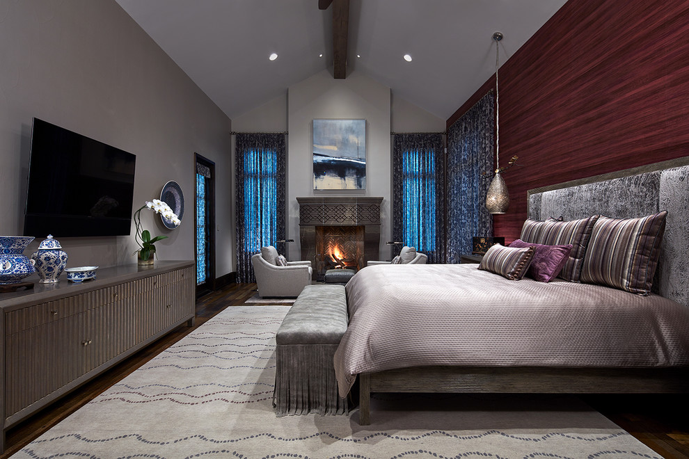 Large transitional master bedroom in Dallas with medium hardwood floors, a standard fireplace, a stone fireplace surround, brown floor and grey walls.