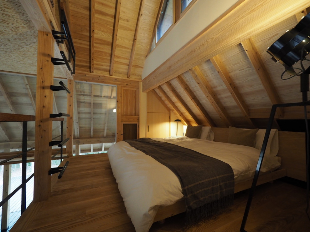 This is an example of a small asian master bedroom in Other with white walls, light hardwood floors, beige floor and exposed beam.