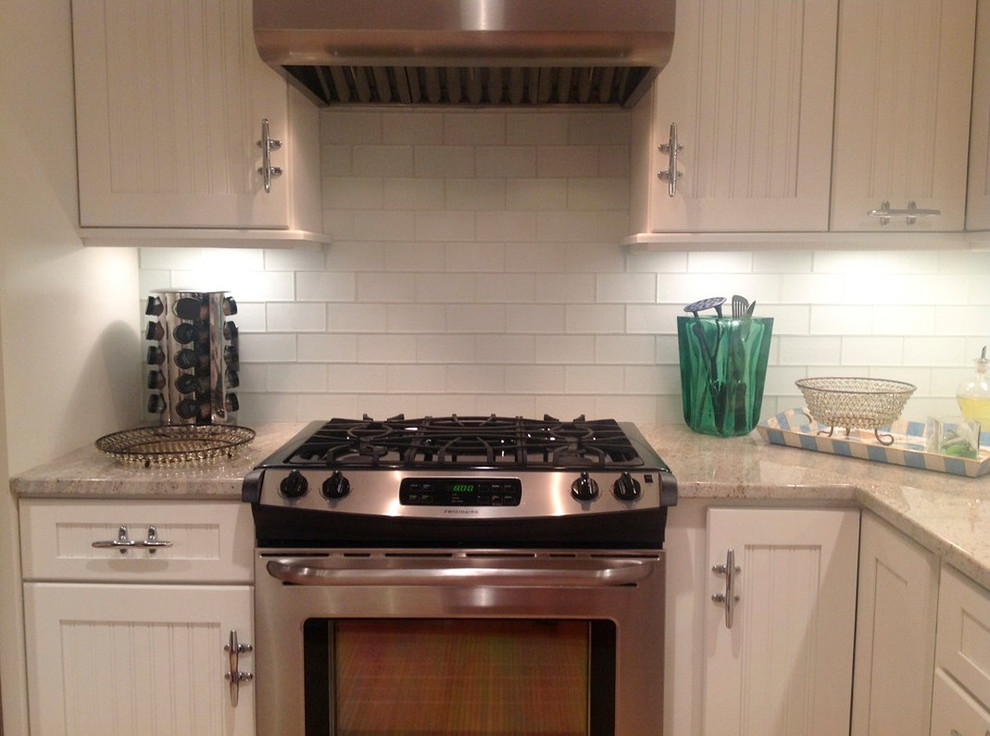 Transitional kitchen photo with recessed-panel cabinets, white cabinets, granite countertops, white backsplash and glass tile backsplash