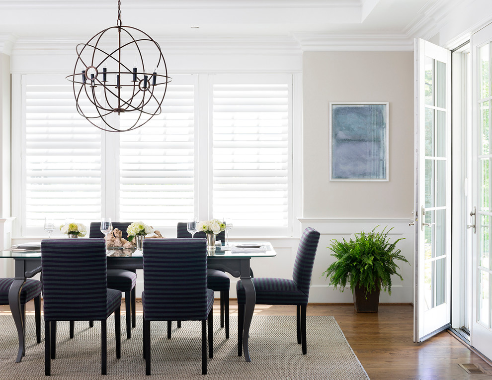 Example of a large transitional medium tone wood floor enclosed dining room design in DC Metro with beige walls and no fireplace