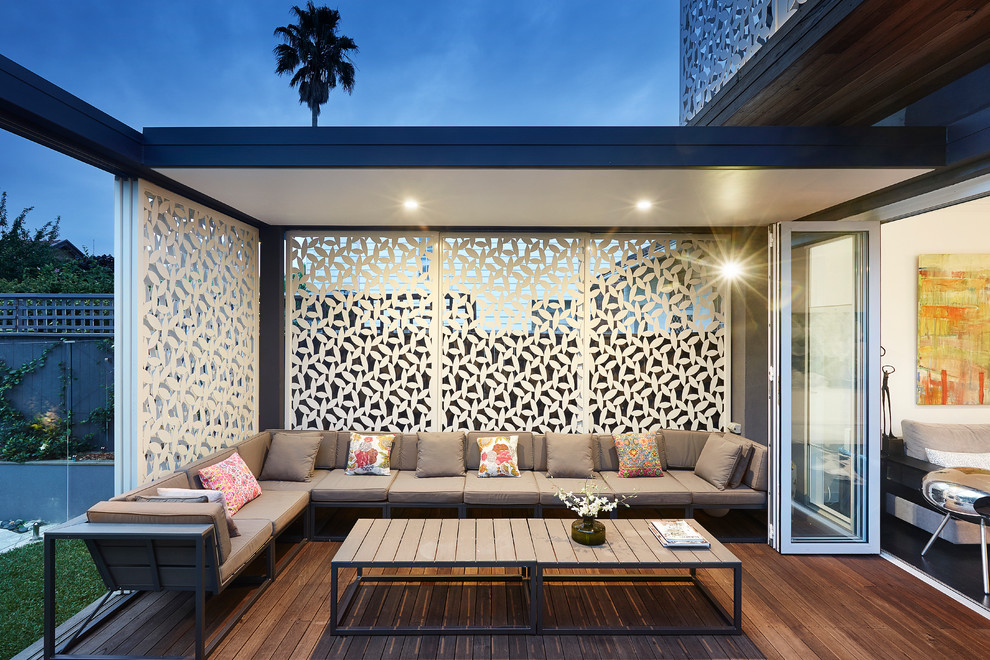 This is an example of a contemporary backyard deck in Sydney with a roof extension.