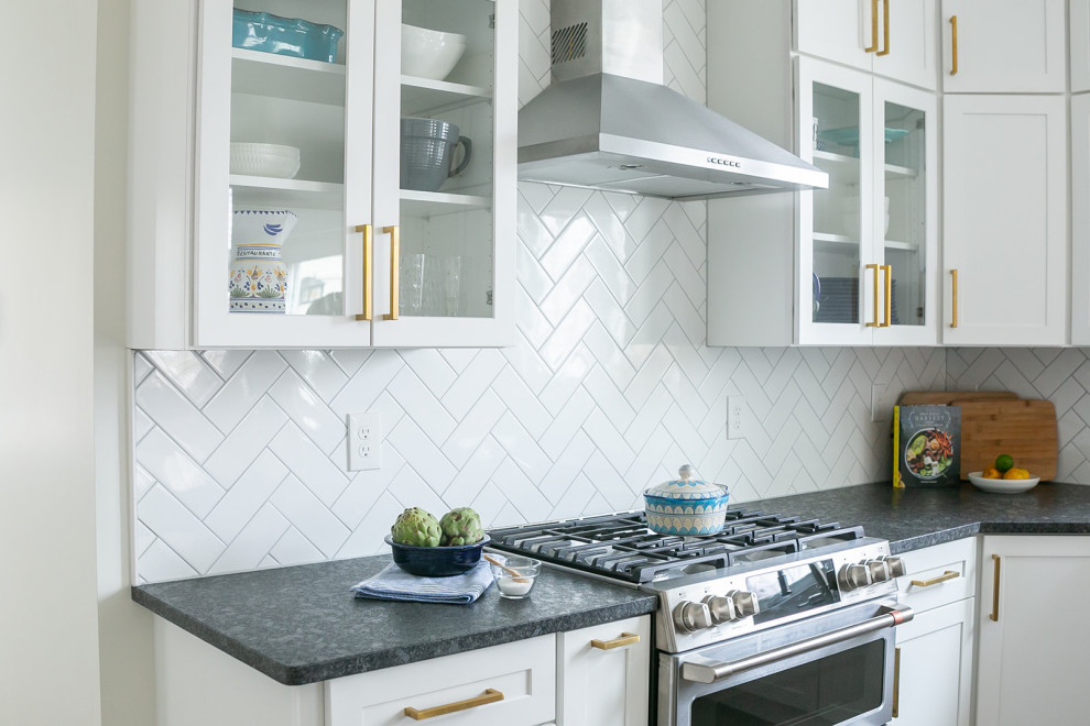 Example of a large transitional l-shaped brown floor kitchen pantry design in Baltimore with a drop-in sink, shaker cabinets, white cabinets, quartz countertops, white backsplash, ceramic backsplash, stainless steel appliances, an island and white countertops