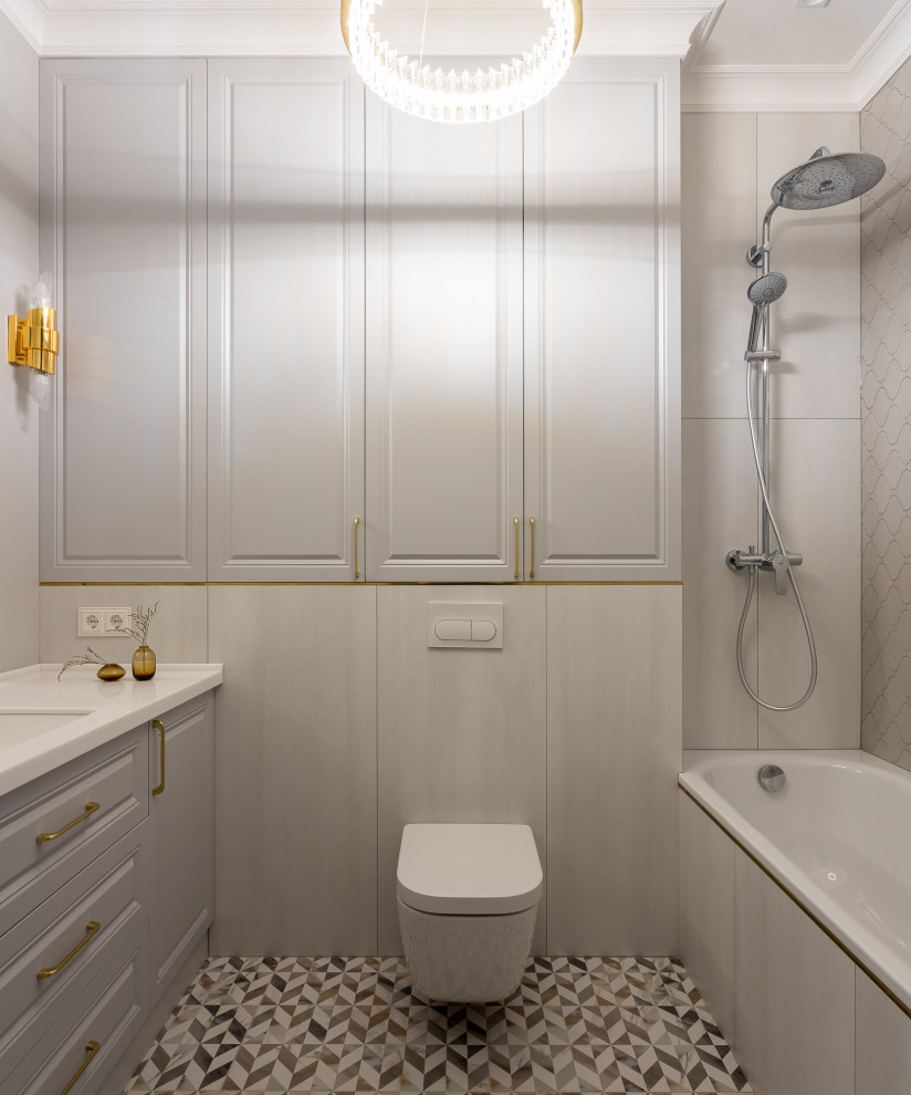 Design ideas for a medium sized traditional ensuite bathroom in Other with raised-panel cabinets, grey cabinets, an alcove bath, a shower/bath combination, a wall mounted toilet, grey tiles, porcelain tiles, grey walls, ceramic flooring, a submerged sink, engineered stone worktops, multi-coloured floors, an open shower, white worktops, an enclosed toilet, a single sink and a freestanding vanity unit.