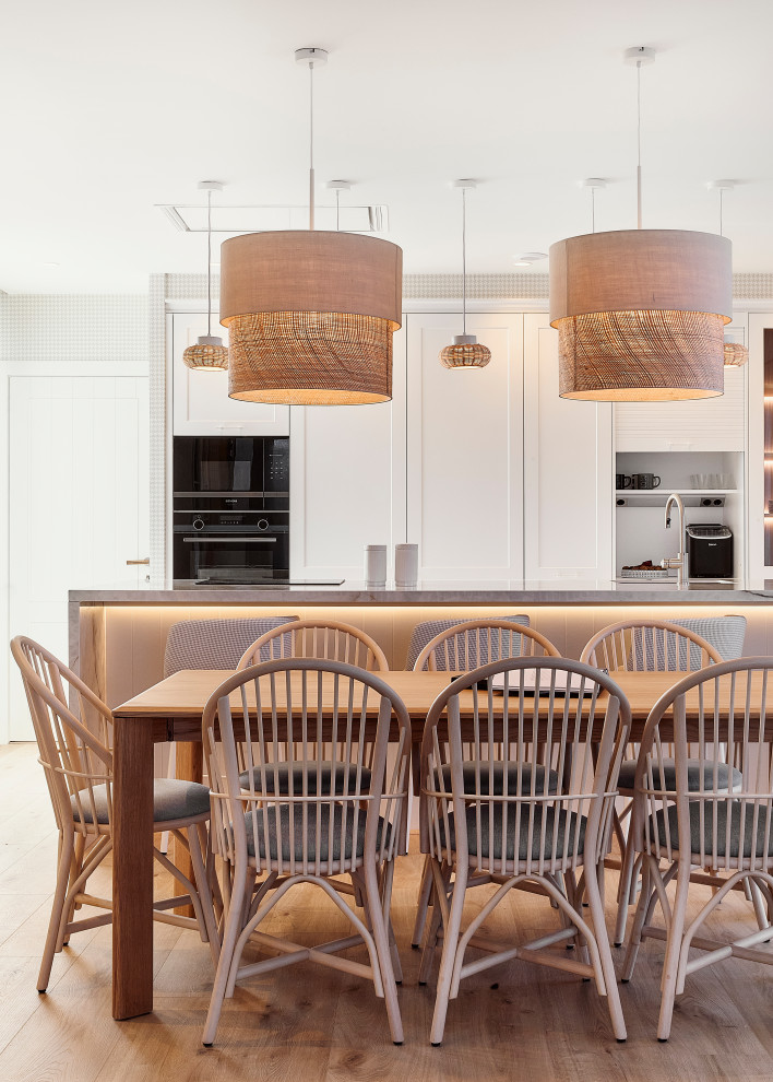 Imagen de comedor de cocina clásico renovado grande sin chimenea con paredes beige, suelo laminado, suelo marrón y papel pintado