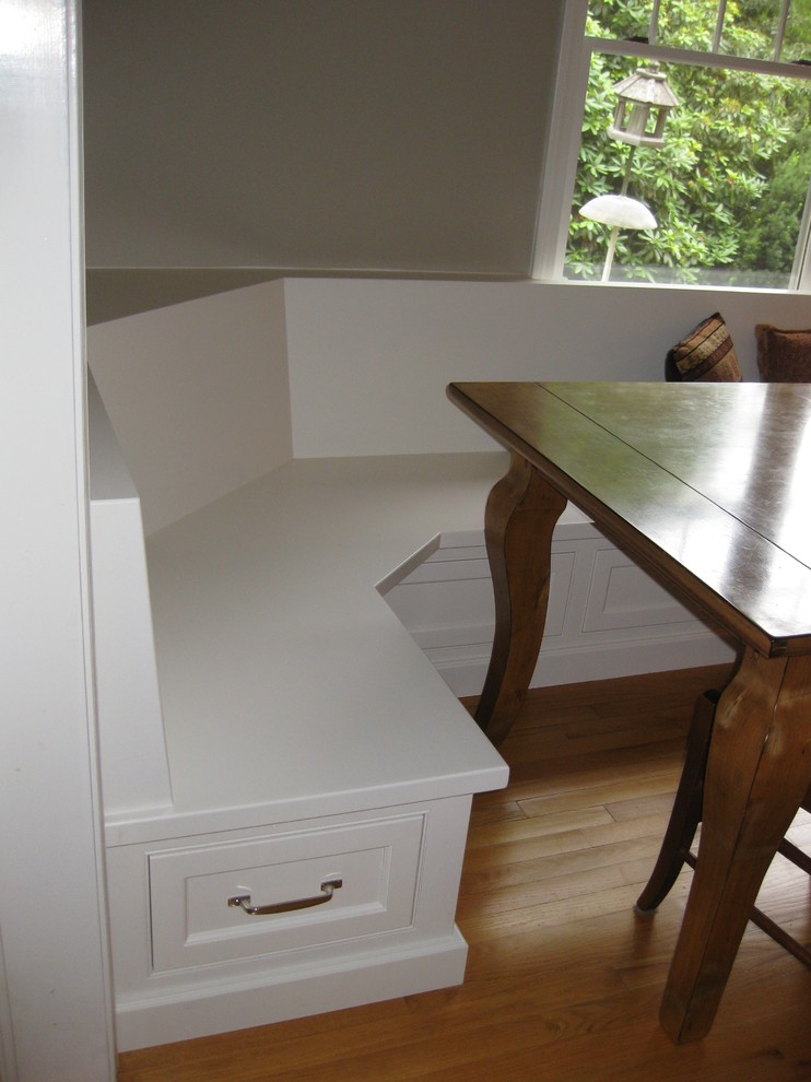 Eat-in kitchen - transitional u-shaped medium tone wood floor eat-in kitchen idea in Boston with an undermount sink, recessed-panel cabinets, white cabinets, gray backsplash, subway tile backsplash, stainless steel appliances, an island and black countertops