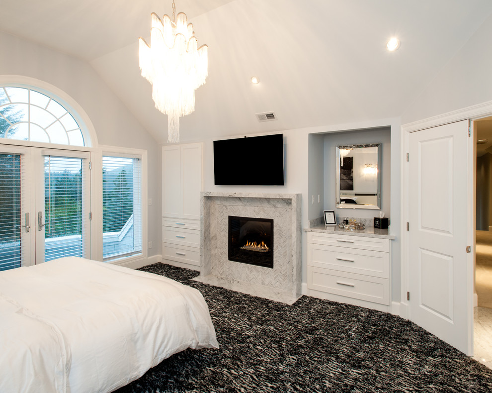 Large modern master bedroom in Seattle with grey walls, carpet, a standard fireplace and a stone fireplace surround.