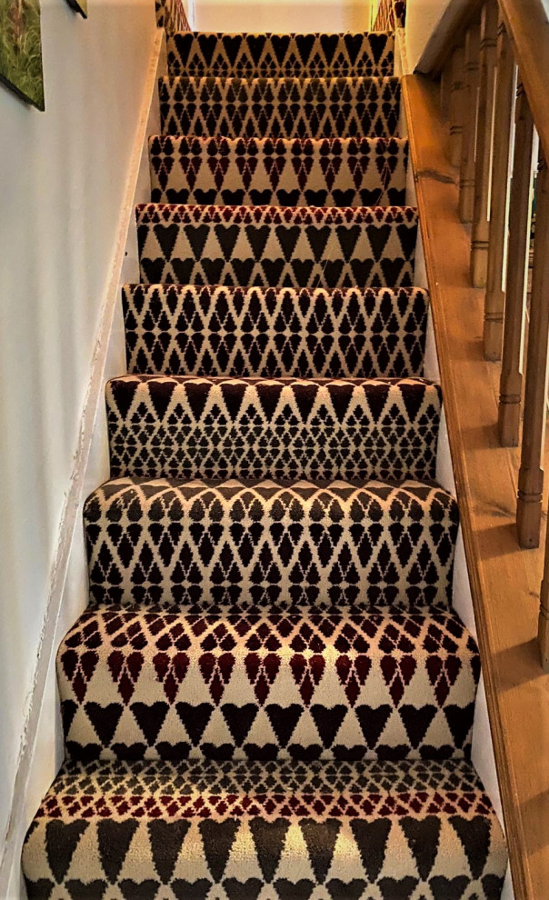 Staircase - mid-sized contemporary carpeted straight wood railing staircase idea in Hertfordshire with carpeted risers