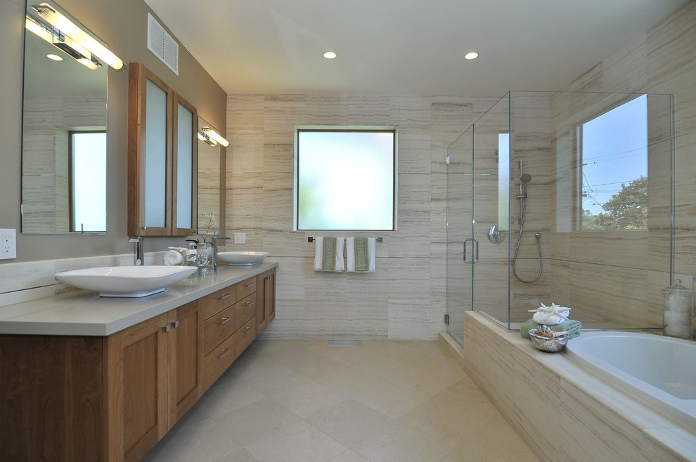 Design ideas for a transitional bathroom in San Francisco with a vessel sink, medium wood cabinets, engineered quartz benchtops, a drop-in tub, a corner shower, beige tile, beige walls, ceramic floors, shaker cabinets and travertine.
