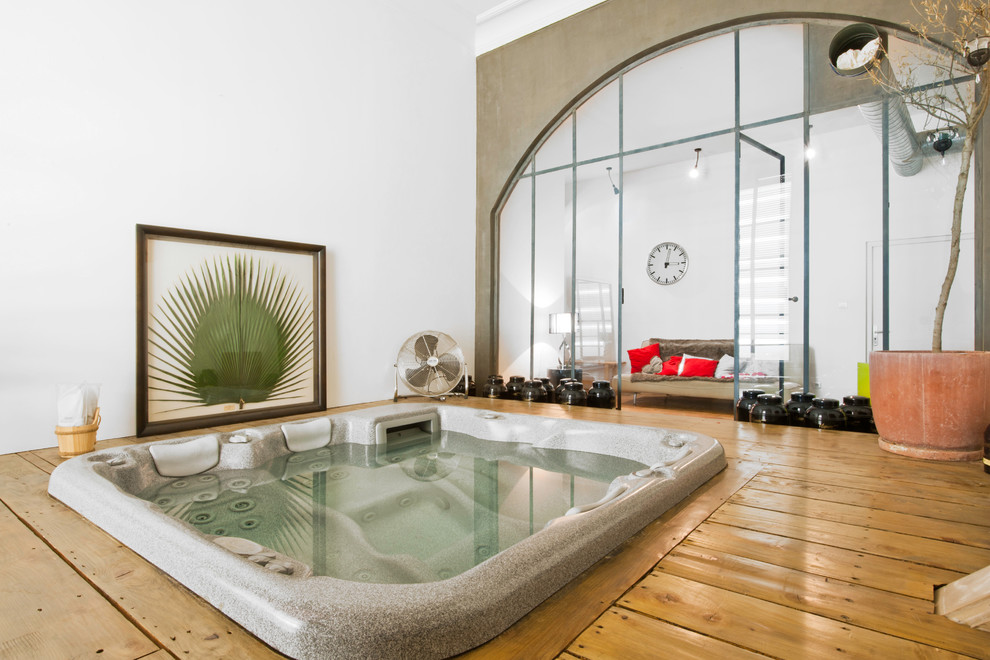 This is an example of a mid-sized asian indoor rectangular pool in Lyon with a hot tub and decking.