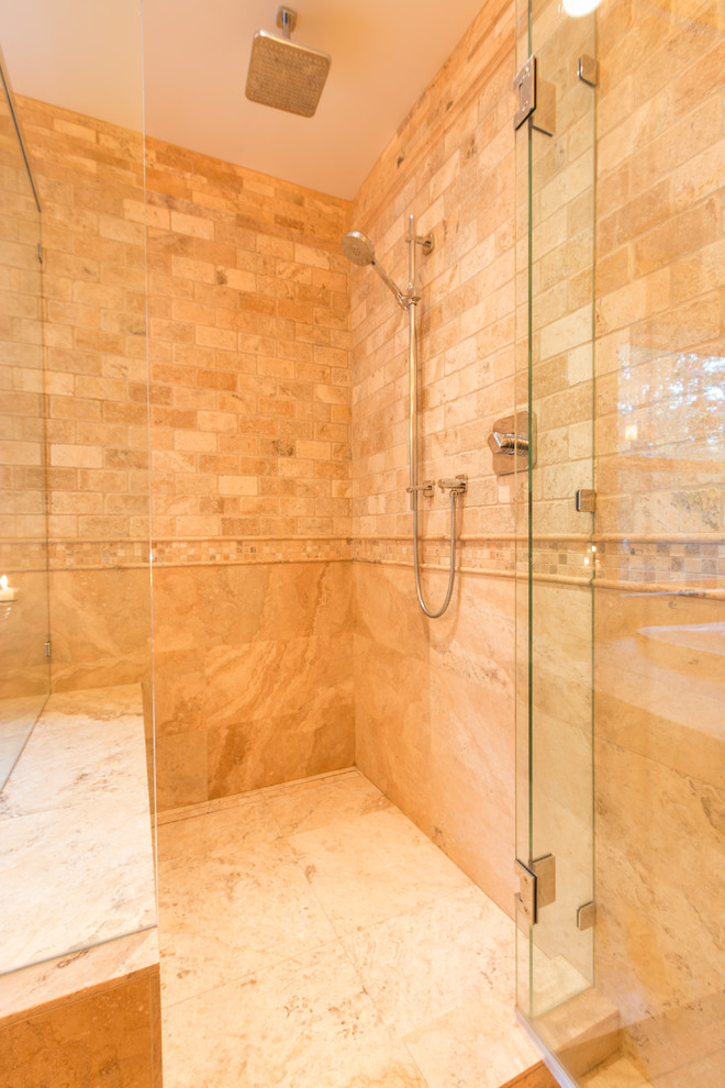 This is an example of a large traditional master bathroom in Vancouver with a drop-in tub, an alcove shower, multi-coloured tile, stone tile and travertine floors.