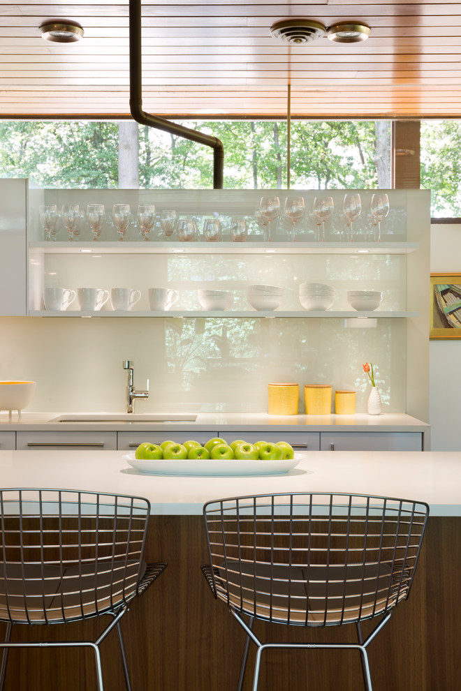 Inspiration for a mid-sized midcentury l-shaped kitchen pantry in DC Metro with an undermount sink, flat-panel cabinets, white cabinets, laminate benchtops, white splashback, with island and brown floor.