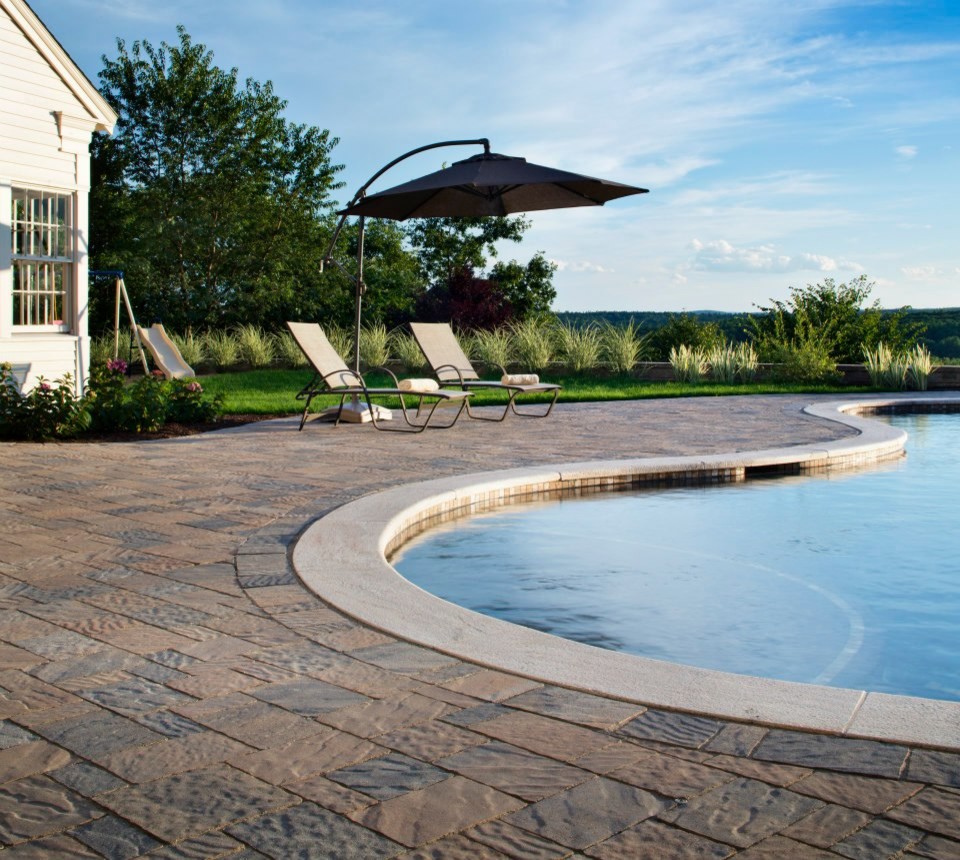This is an example of a mid-sized contemporary backyard kidney-shaped pool in Boston with a hot tub and concrete pavers.