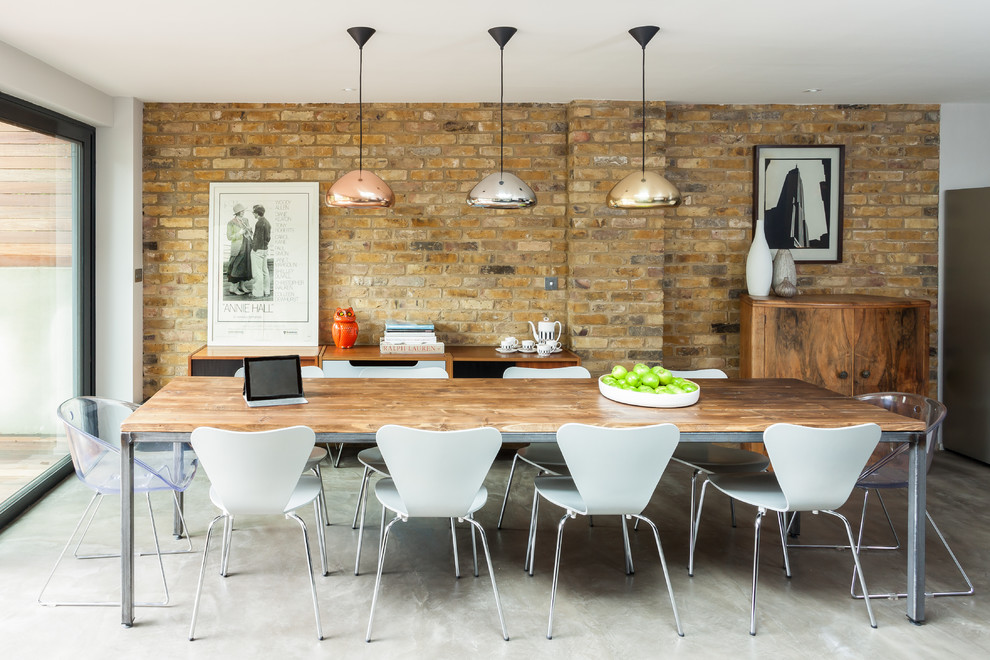 Photo of a contemporary dining room in London with concrete floors.