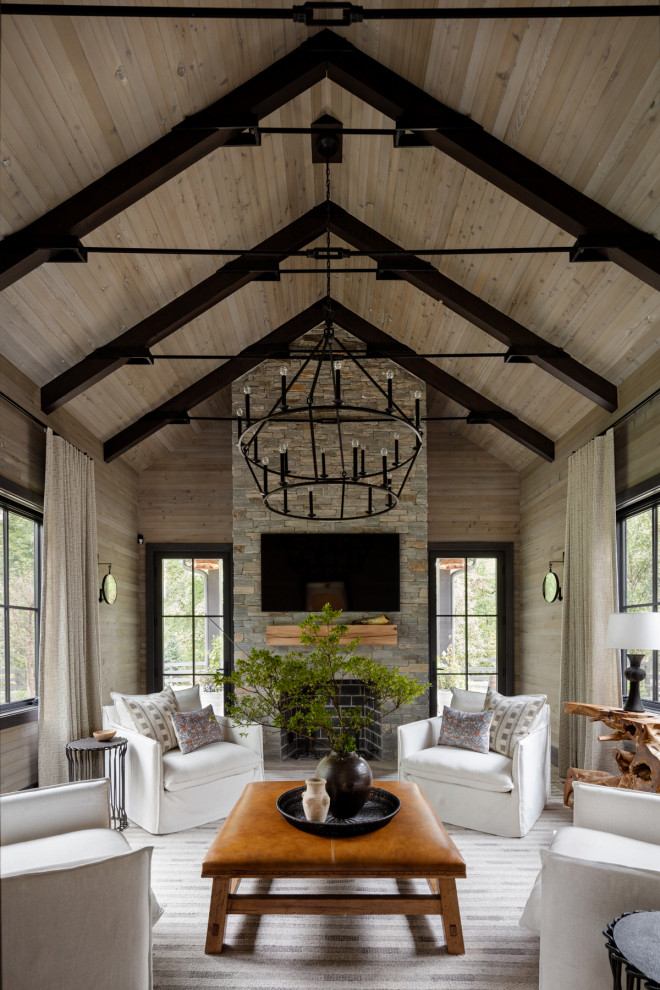 Example of a large cottage brown floor, vaulted ceiling, exposed beam, wood ceiling and wood wall family room design in DC Metro with brown walls, a standard fireplace and a stacked stone fireplace