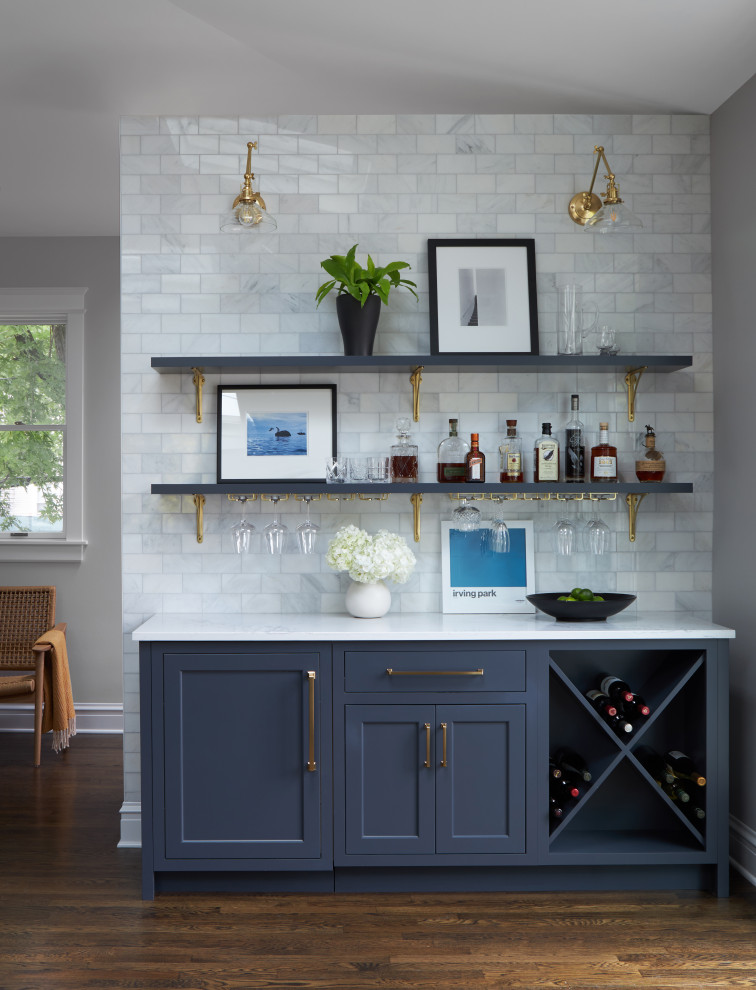 Photo of a medium sized classic single-wall dry bar in Chicago with no sink, shaker cabinets, blue cabinets, marble worktops, white splashback, metro tiled splashback, medium hardwood flooring, brown floors and white worktops.