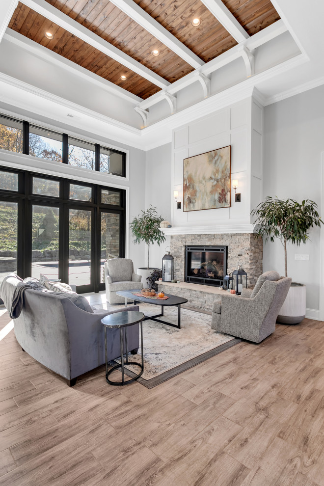 Photo of an expansive modern formal open concept living room in Other with grey walls, ceramic floors, a standard fireplace, a stone fireplace surround, grey floor, coffered and panelled walls.