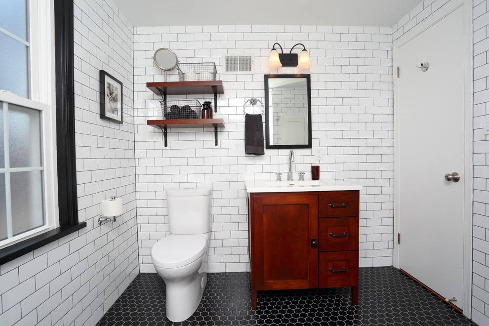This is an example of a mid-sized traditional master bathroom in Milwaukee with shaker cabinets, medium wood cabinets, an alcove tub, an alcove shower, a two-piece toilet, white tile, ceramic tile, white walls, ceramic floors, an undermount sink and marble benchtops.